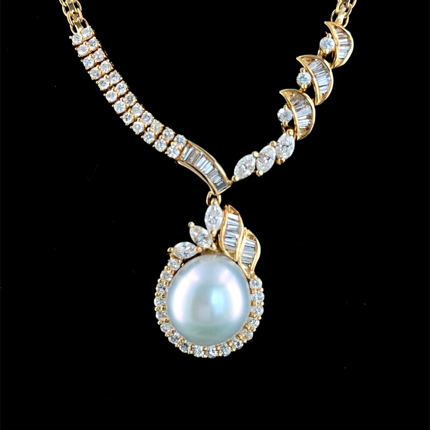 A Stunning 18k Yellow Gold 11mm South Sea Pearl & Diamond Pendant Suspended on A Byzantine Chain. Appx 1.65 Cts Marquise,Round Cut & Baguette Diamonds of F-G Colour VS- Si1 Clarity. Part Of The Ronald Charles Collection.