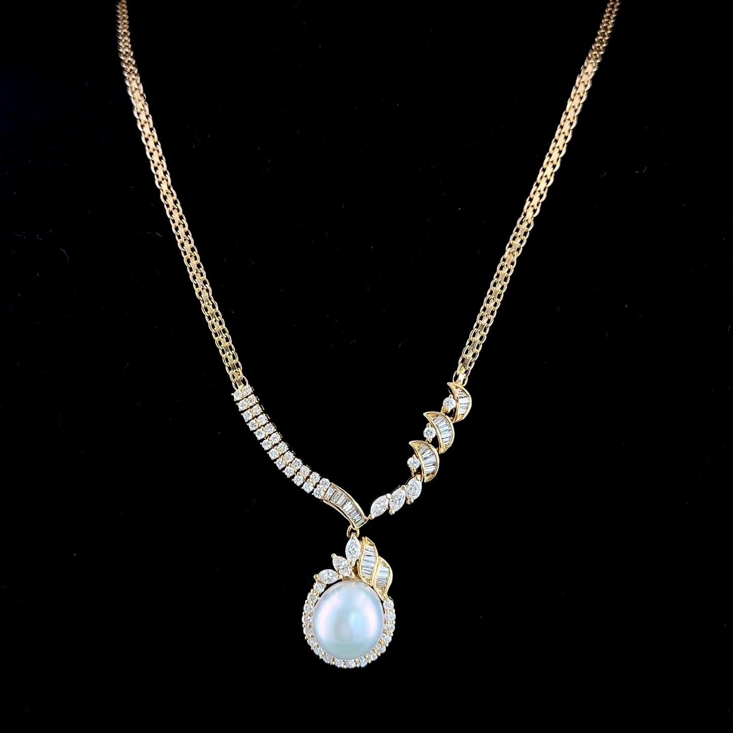 A Stunning 18k Yellow Gold 11mm South Sea Pearl & Diamond Pendant Suspended on A Byzantine Chain. Appx 1.65 Cts Marquise,Round Cut & Baguette Diamonds of F-G Colour VS- Si1 Clarity. Part Of The Ronald Charles Collection.
