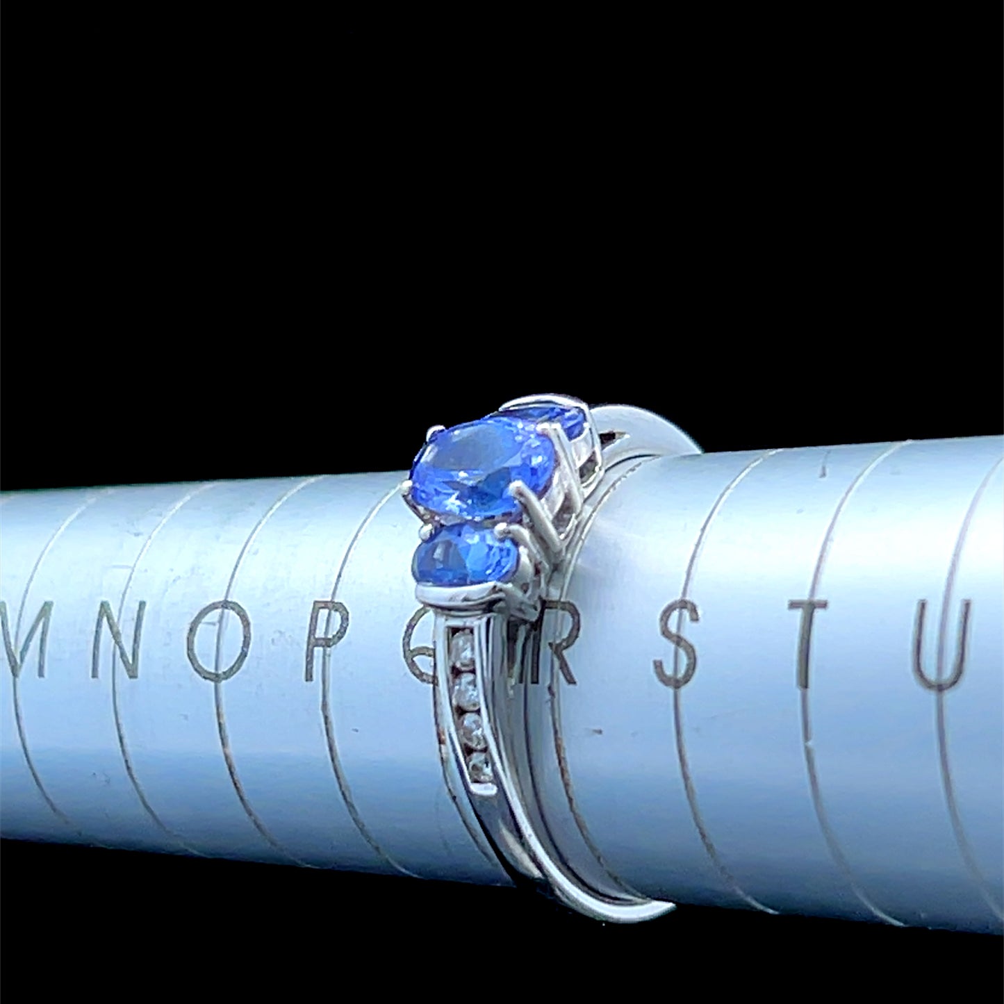 9K White Gold Tanzanite Trilogy Ring With Channel Set Diamonds To Shoulders