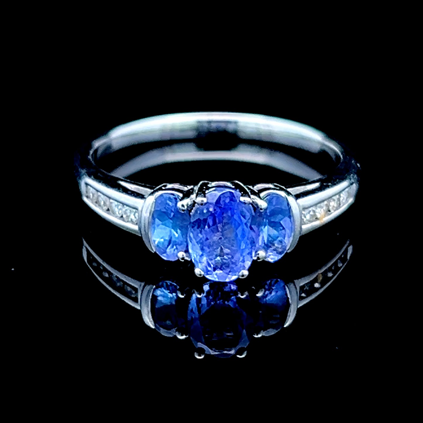 9K White Gold Tanzanite Trilogy Ring With Channel Set Diamonds To Shoulders