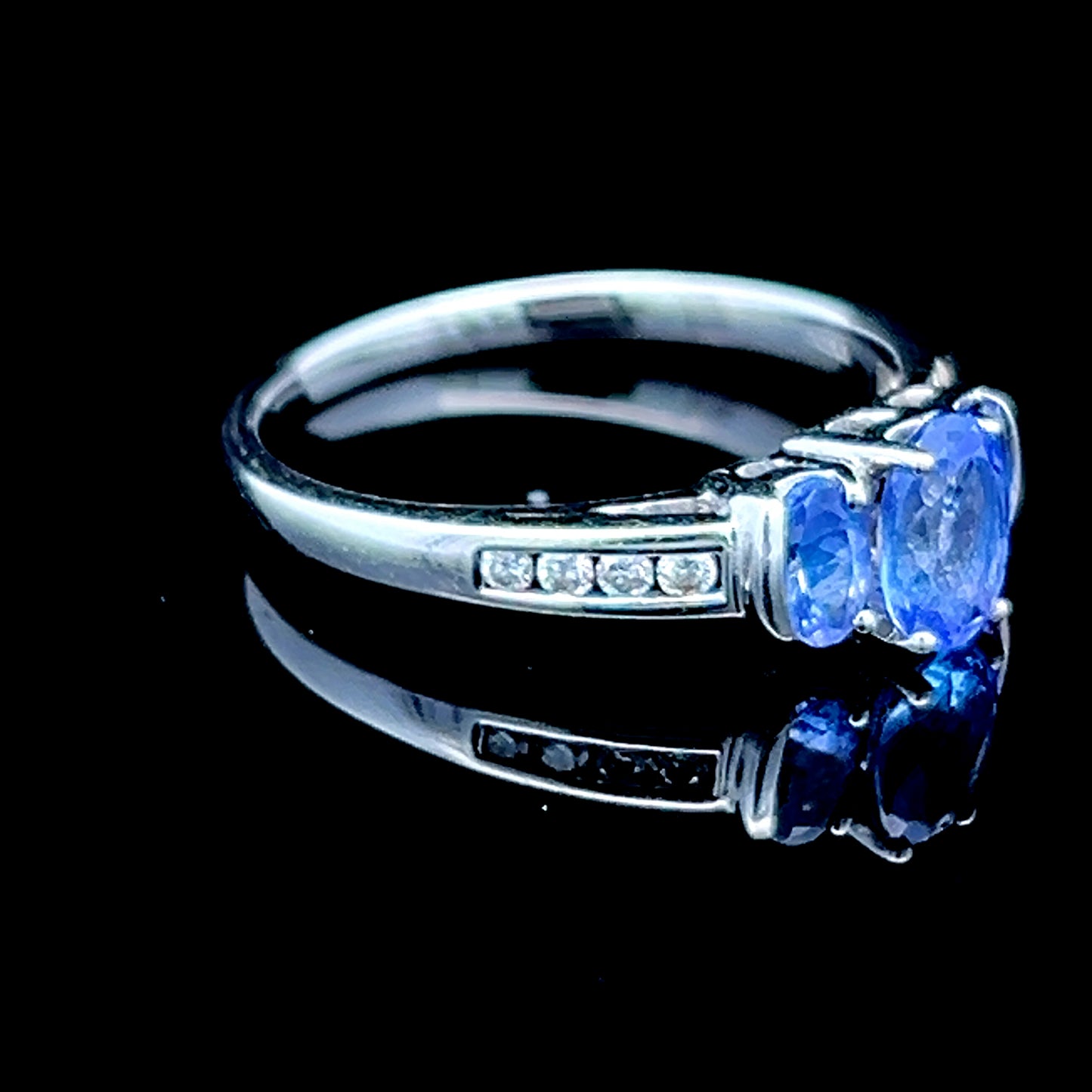 9K White Gold Tanzanite Trilogy Ring With Channel Set Diamonds To Shoulders
