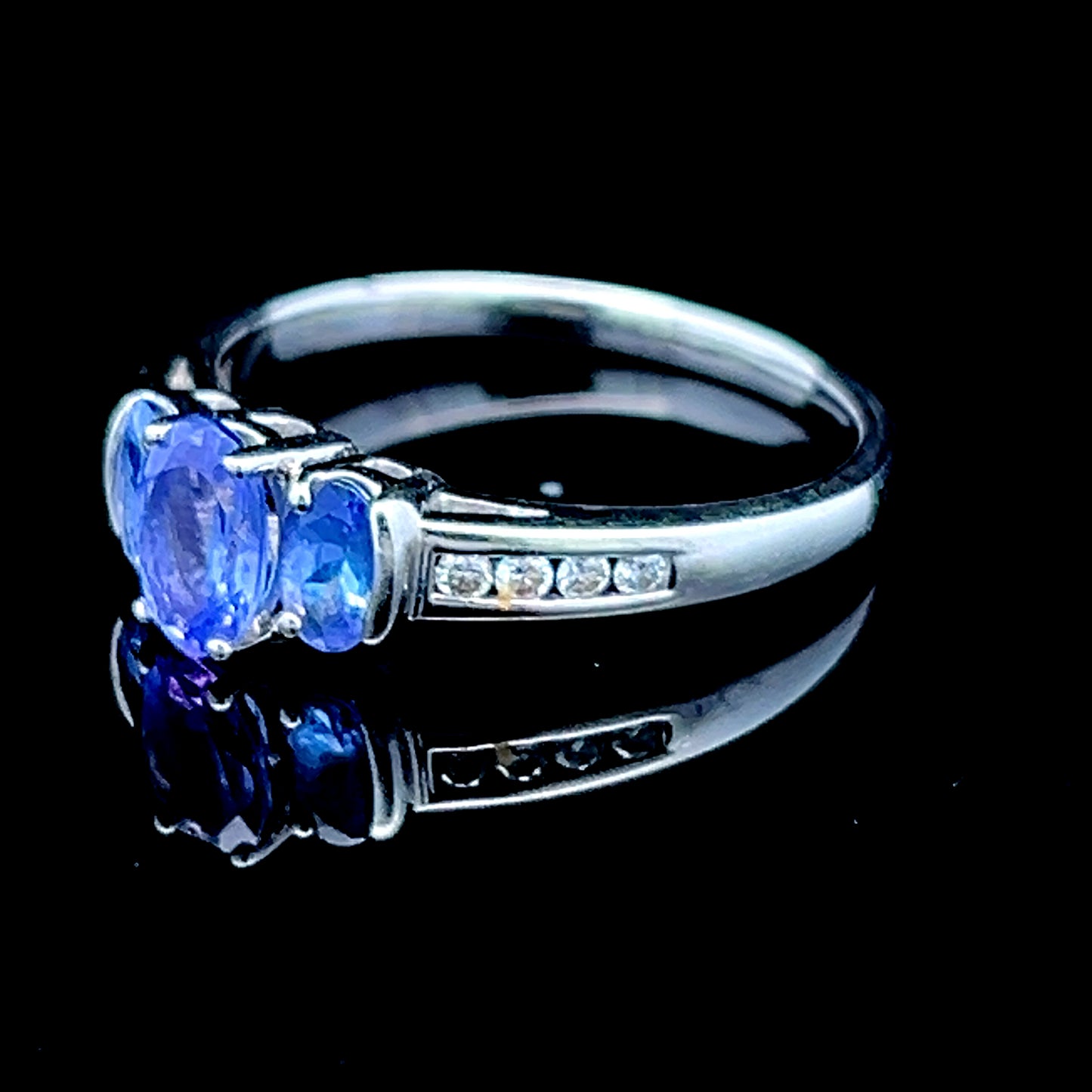9K White Gold Tanzanite Trilogy Ring With Channel Set Diamonds To Shoulders