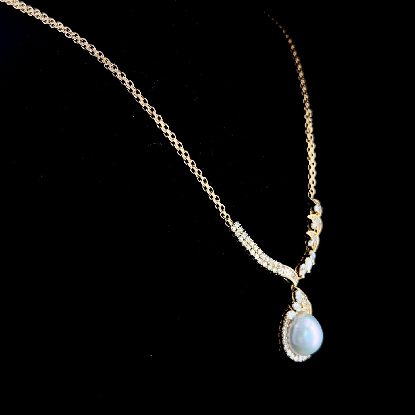 A Stunning 18k Yellow Gold 11mm South Sea Pearl & Diamond Pendant Suspended on A Byzantine Chain. Appx 1.65 Cts Marquise,Round Cut & Baguette Diamonds of F-G Colour VS- Si1 Clarity. Part Of The Ronald Charles Collection.