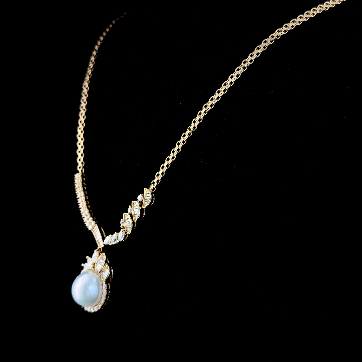 A Stunning 18k Yellow Gold 11mm South Sea Pearl & Diamond Pendant Suspended on A Byzantine Chain. Appx 1.65 Cts Marquise,Round Cut & Baguette Diamonds of F-G Colour VS- Si1 Clarity. Part Of The Ronald Charles Collection.
