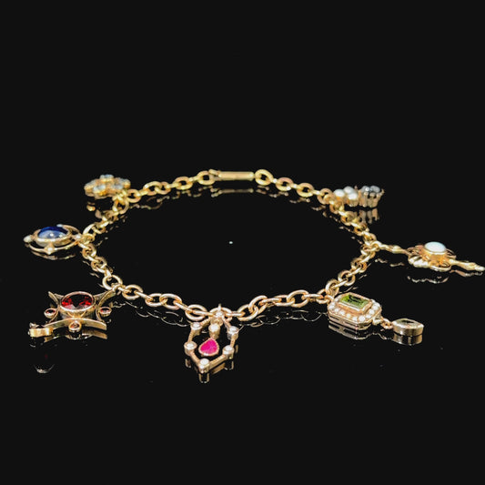 A Spectacular Victorian 9k Yellow Gold Charm Bracelet Having Sapphire, Pearl, Garnet, Aqua & Peridot Articulated Charms. 8” in Length.