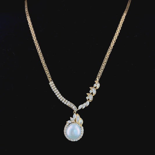 A Stunning 18k Yellow Gold 11mm South Sea Pearl & Diamond Pendant Suspended on A Byzantine Chain. Appx 1.65 Cts Marquise,Round Cut & Baguette Diamonds of F-G Colour VS- Si1 Clarity. Part Of The Ronald Charles Collection.